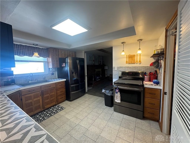 kitchen featuring backsplash, stainless steel appliances, a sink, and a fireplace