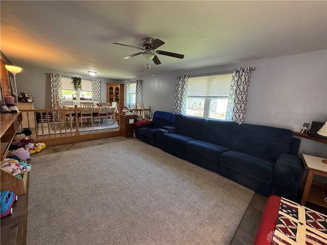 living room featuring a ceiling fan, carpet, and a wealth of natural light