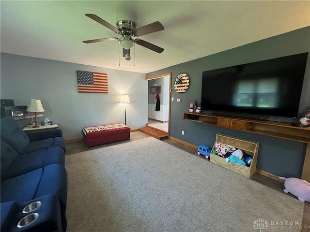 carpeted living room featuring ceiling fan and baseboards