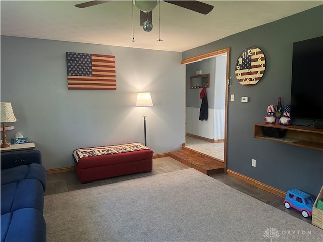 living room featuring baseboards and ceiling fan