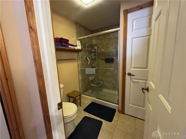 full bathroom with toilet, tile patterned floors, and a stall shower