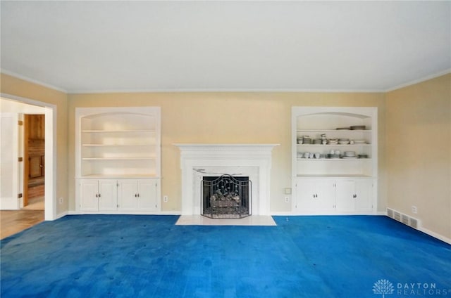 unfurnished living room featuring crown molding, built in shelves, baseboards, a fireplace with flush hearth, and visible vents
