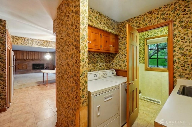 laundry room with cabinet space, washer and dryer, a sink, wallpapered walls, and visible vents