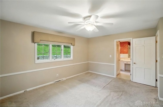 unfurnished bedroom featuring ceiling fan, visible vents, baseboards, connected bathroom, and carpet