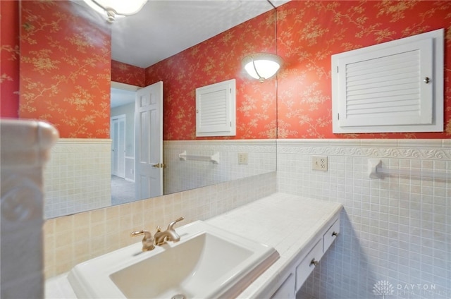 bathroom featuring tile patterned floors, tile walls, wainscoting, and vanity