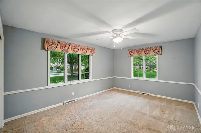 empty room featuring visible vents, carpet flooring, and baseboards