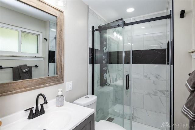 full bathroom featuring vanity, toilet, and a marble finish shower