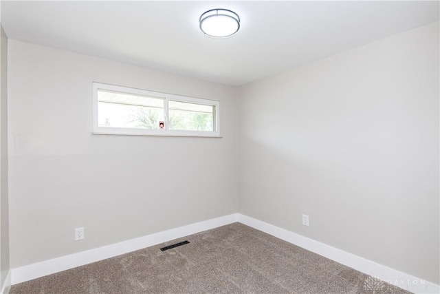 carpeted spare room with baseboards and visible vents