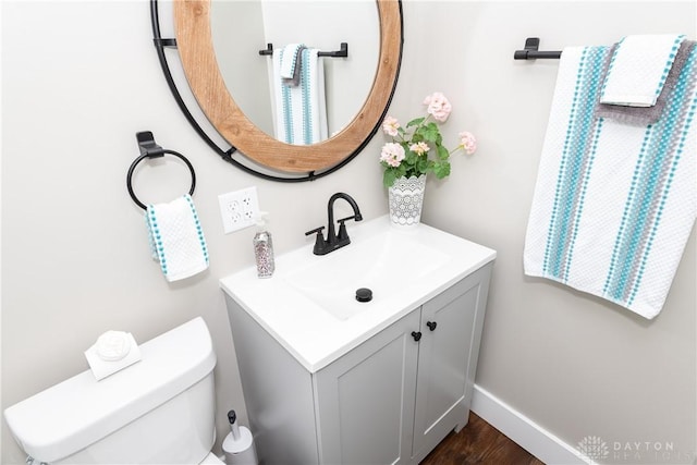 bathroom with vanity, baseboards, toilet, and wood finished floors