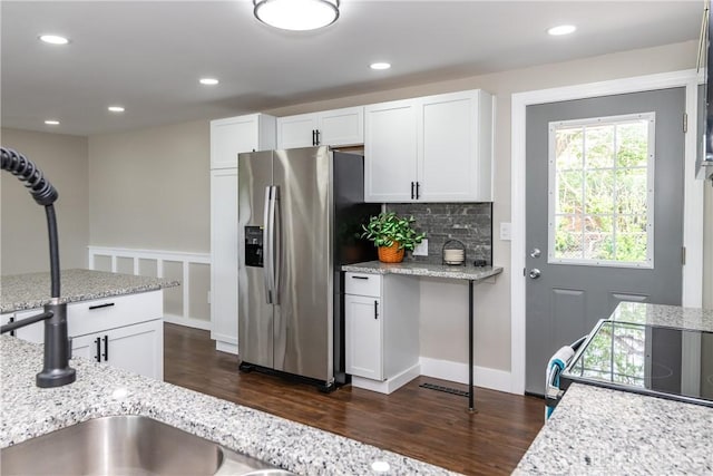 kitchen featuring dark wood-style flooring, light stone countertops, recessed lighting, white cabinetry, and stainless steel fridge with ice dispenser