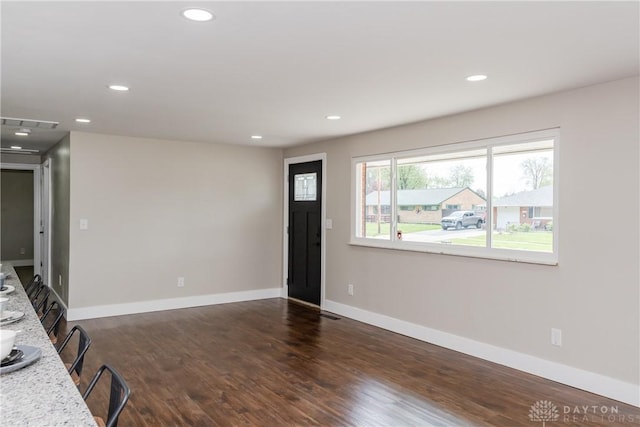 unfurnished living room featuring recessed lighting, baseboards, visible vents, and dark wood-type flooring