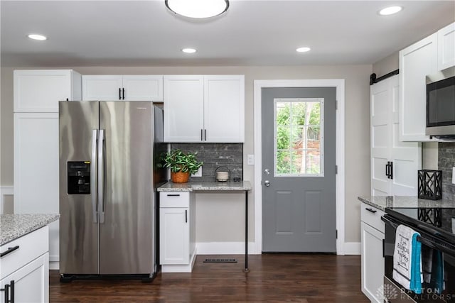 kitchen featuring backsplash, white cabinets, appliances with stainless steel finishes, and light stone counters
