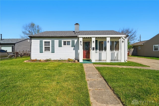 bungalow-style home featuring covered porch, a chimney, fence, a front lawn, and a shingled roof