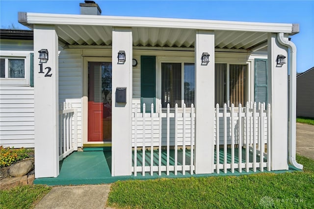 doorway to property with a chimney and a porch
