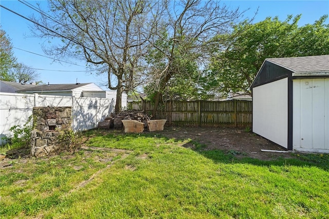 view of yard featuring an outdoor structure, a fenced backyard, and a storage unit
