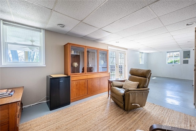 sitting room with a drop ceiling and french doors