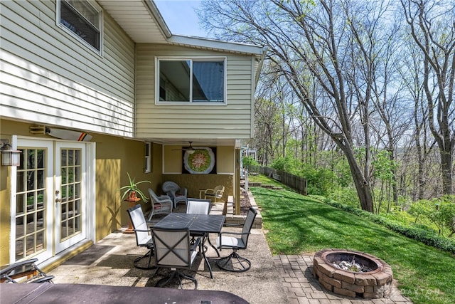 view of patio / terrace featuring outdoor dining area, a fire pit, and french doors