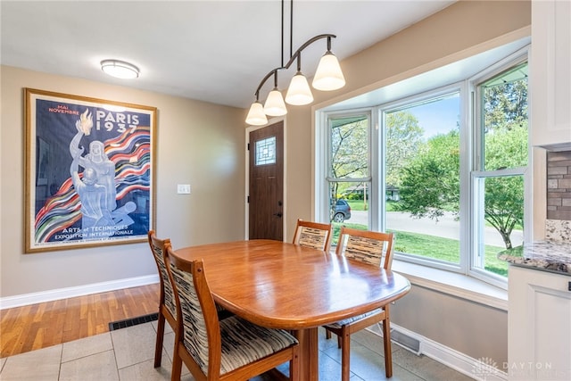 dining room featuring a healthy amount of sunlight, baseboards, and light tile patterned floors
