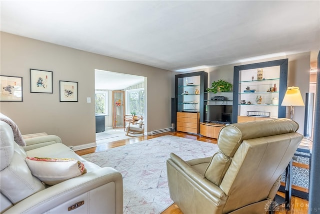 living area with baseboards, a baseboard heating unit, and wood finished floors