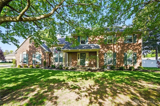 view of front of home featuring brick siding and a front yard