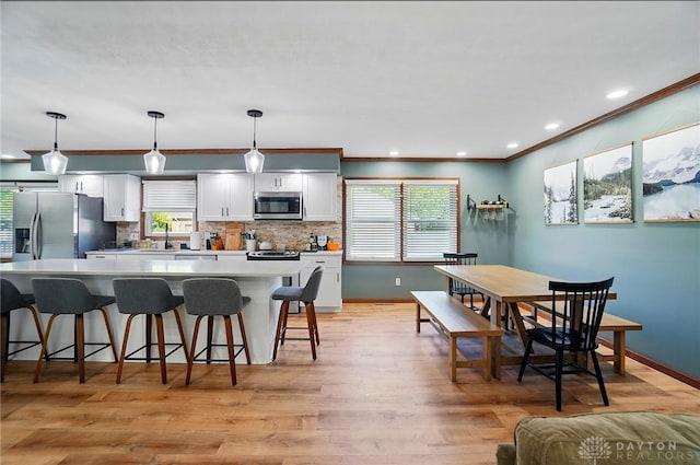 kitchen with appliances with stainless steel finishes, a kitchen bar, a kitchen island, and a healthy amount of sunlight