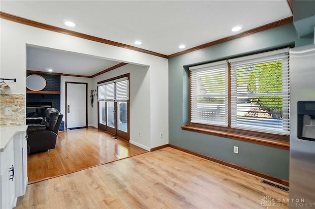 living area with french doors, visible vents, wood finished floors, baseboards, and ornamental molding
