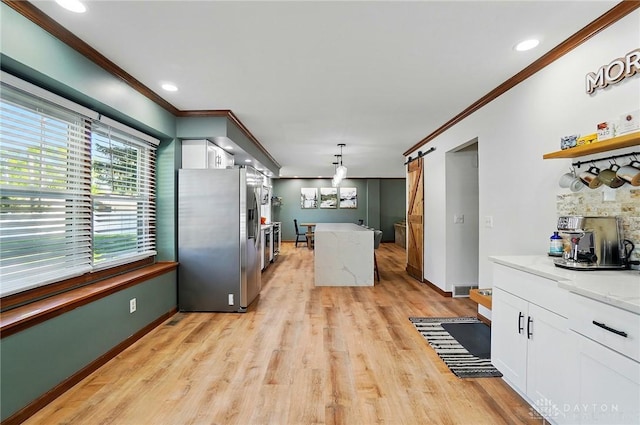 kitchen featuring crown molding, white cabinets, a barn door, light wood-type flooring, and stainless steel refrigerator with ice dispenser