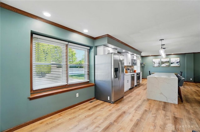kitchen with crown molding, decorative backsplash, white cabinets, and stainless steel appliances