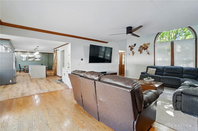 living area with ceiling fan, ornamental molding, and light wood-type flooring