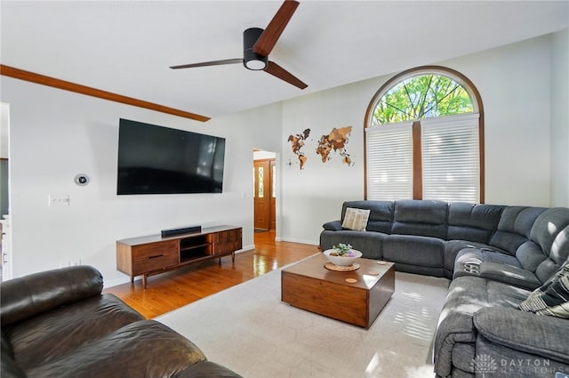 living area featuring baseboards, ceiling fan, and wood finished floors