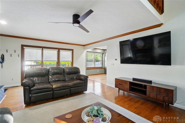 living room with ceiling fan, baseboards, ornamental molding, and wood finished floors