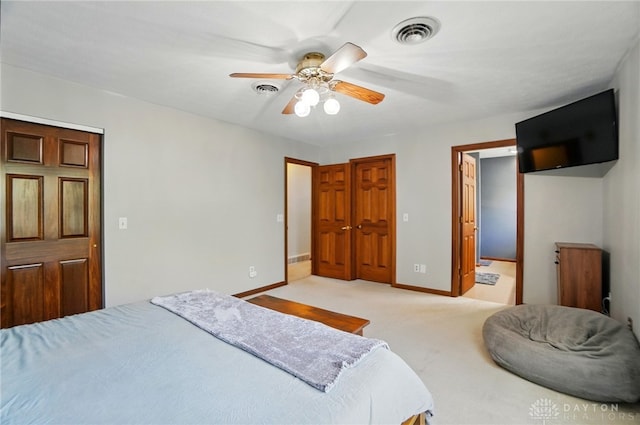 bedroom featuring visible vents, a ceiling fan, baseboards, and light colored carpet