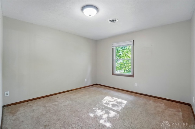 spare room featuring baseboards, carpet flooring, and visible vents