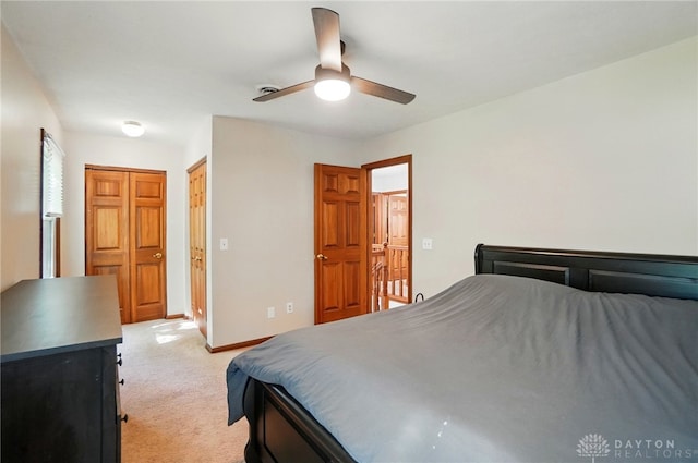 bedroom featuring baseboards, ceiling fan, and light carpet