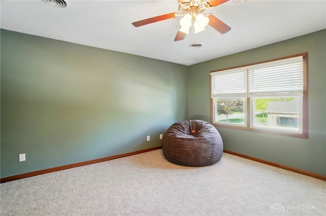 living area with carpet flooring, baseboards, visible vents, and ceiling fan
