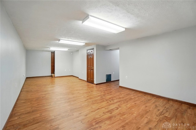 spare room featuring baseboards and light wood-type flooring