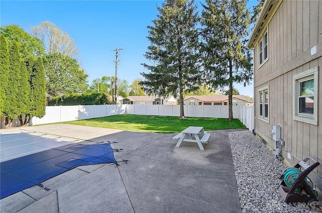 view of swimming pool with a lawn, a fenced backyard, and a patio area