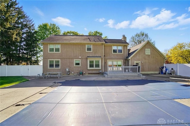 back of property featuring a patio, fence, and a chimney