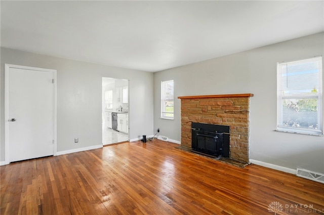 38 Homeview Dr, Harrison Twp, OH 45415 - unfurnished living room featuring visible vents, baseboards, a fireplace, and hardwood / wood-style flooring