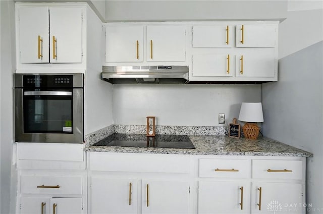 38 Homeview Dr, Harrison Twp, OH 45415 - kitchen with oven, light stone countertops, black electric cooktop, white cabinetry, and under cabinet range hood