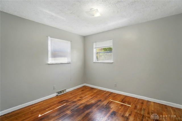 38 Homeview Dr, Harrison Twp, OH 45415 - spare room featuring wood-type flooring, a textured ceiling, baseboards, and visible vents
