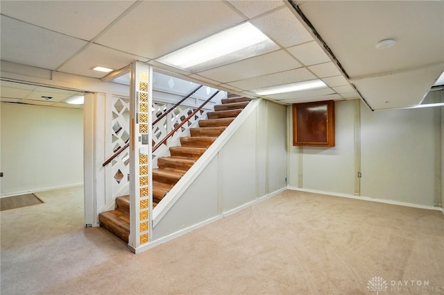 38 Homeview Dr, Harrison Twp, OH 45415 - finished below grade area featuring stairway, baseboards, a paneled ceiling, and light colored carpet