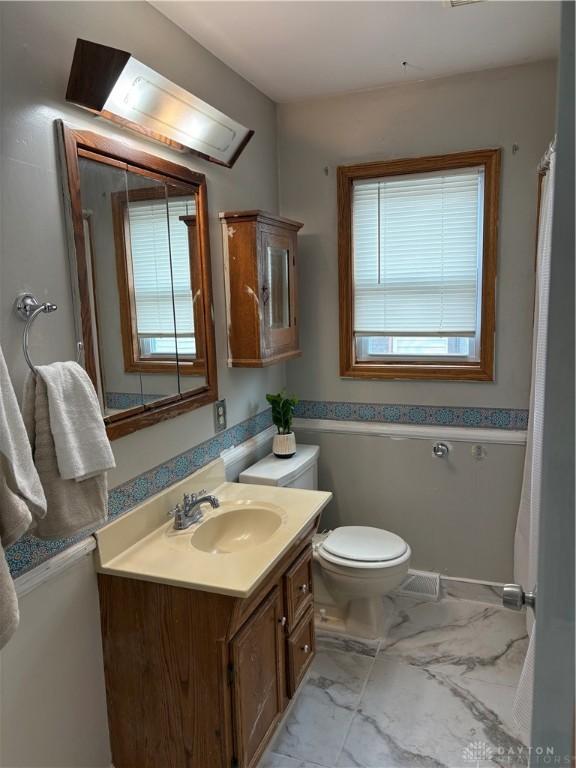 38 Homeview Dr, Harrison Twp, OH 45415 - bathroom featuring vanity, toilet, and marble finish floor