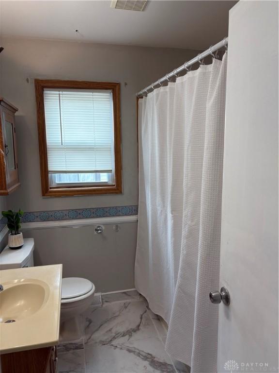 38 Homeview Dr, Harrison Twp, OH 45415 - full bath featuring vanity, toilet, a shower with shower curtain, marble finish floor, and visible vents