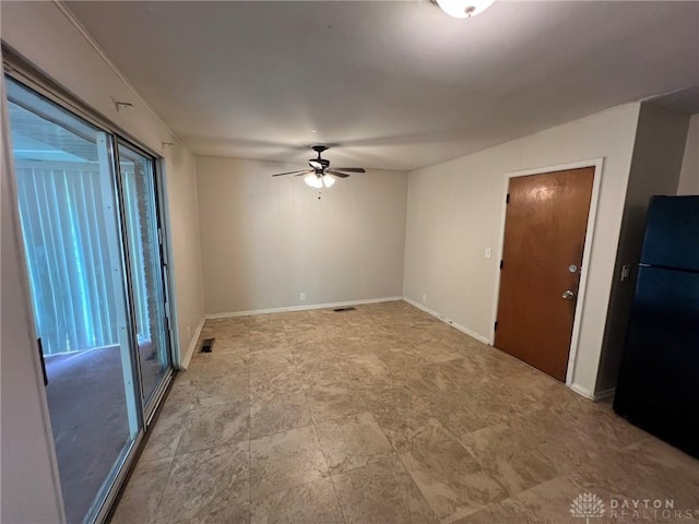 spare room featuring baseboards, a ceiling fan, and visible vents