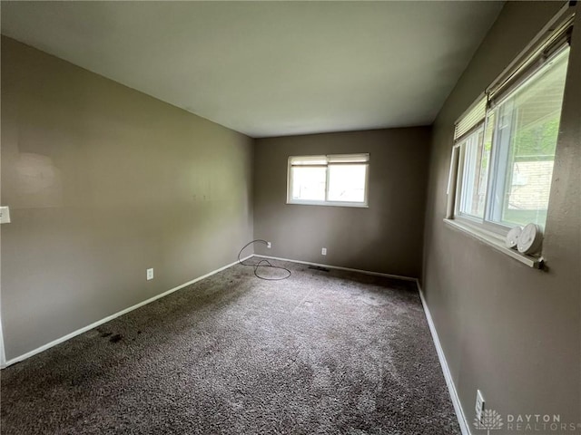 unfurnished room with baseboards and carpet flooring