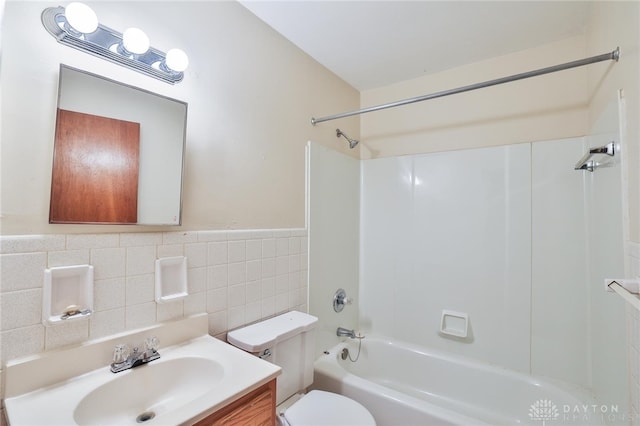 5565 Ehrling Rd, Cincinnati, OH 45227 - bathroom featuring tile walls, toilet, bathtub / shower combination, vanity, and wainscoting