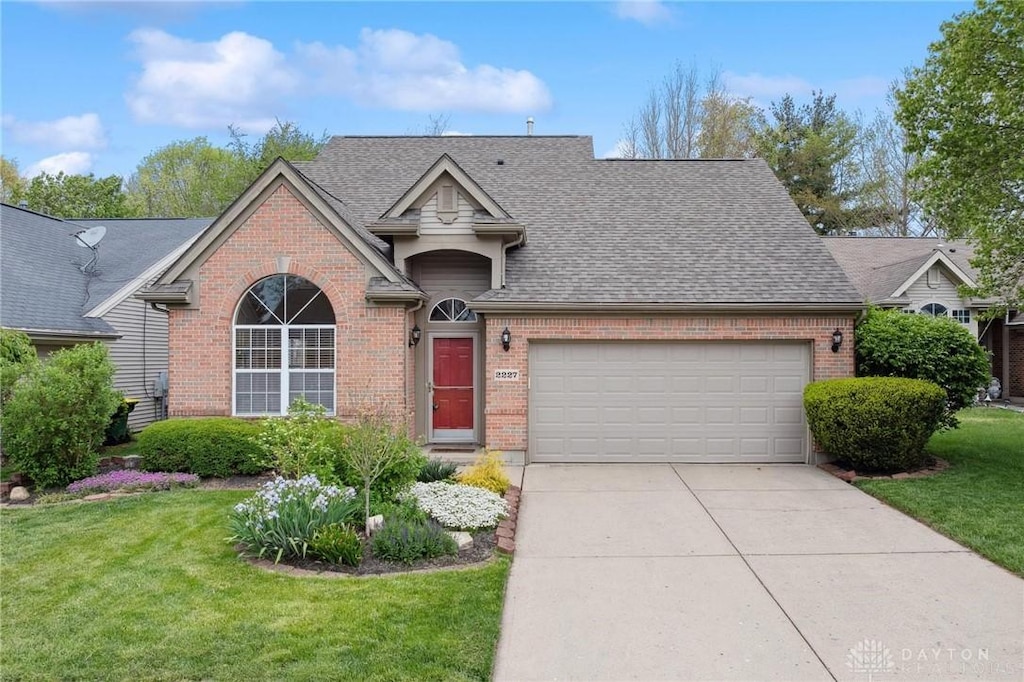 single story home featuring brick siding, a garage, and a front lawn