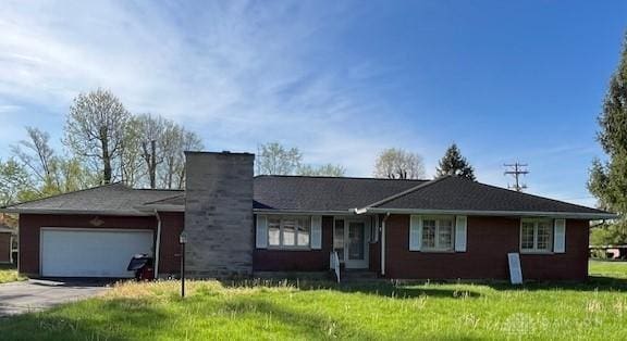 ranch-style house with an attached garage, concrete driveway, a front lawn, and a chimney