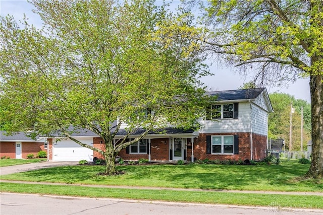 traditional-style house with brick siding, a garage, a front lawn, and driveway